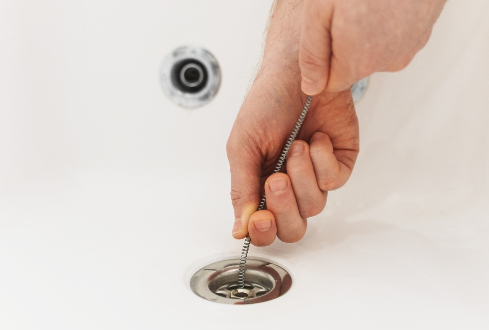 Home Close-up of a professional plumber using a drain snake to clear a clogged bathtub drain, showcasing expert drain cleaning services by Flow Pro Plumbing. The drain snake technique is ideal for effortlessly unclogging pipes, ensuring efficient plumbing solutions for stubborn blockages. Services include drain cleaning, plumbing repairs, and pipe maintenance. Call us now for help with effortlessly unclog pipes, master drain snake technique, plumbing services, drain cleaning near me, clogged drain repair, professional drain snake, pipe unclogging, plumbing repairs near me, drain blockage removal, drain snake service near me, plumbing maintenance near me, emergency drain cleaning, drain clearing expert, pipe maintenance services, plumbing solutions near me, bathtub drain cleaning, bathroom plumbing services, plumber near me, residential drain cleaning, pipe clog repair near me, Flow Pro Plumbing services, plumbing pipe unclogging, affordable plumbing repairs, drain snake pipe clearing, plumbing upgrades near me.