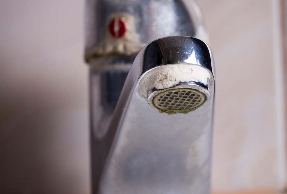 Home A kitchen faucet with white calcium buildup caused by hard water, showing mineral deposits and low water flow issues—Flow Pro Plumbing offers faucet repair, water filtration system installation, and hard water solutions to help remove calcium from faucets. Call us today for help with how to remove calcium from faucet, calcium buildup on faucet, remove hard water stains from faucet, hard water deposits on faucet, white buildup on kitchen faucet, how to clean calcium from faucet aerator, vinegar to remove calcium from faucet, remove limescale from faucet, faucet cleaning tips, faucet repair services, hard water faucet issues, plumbing services for hard water, water softener installation near me, faucet repair near me, hard water plumbing solutions, calcium removal plumbing near me, kitchen faucet repair near me, how to clean faucet buildup, best way to remove hard water stains from faucet, Flow Pro Plumbing faucet services, professional faucet cleaning, water filtration installation near me, remove calcium deposits from bathroom fixtures, mineral buildup in faucet aerator, how to fix clogged faucet due to calcium.